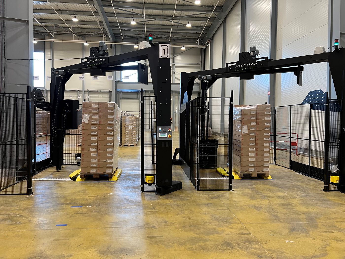 Deux banderoleuses à bras tournant Atecmaa filmant des palettes de cartons