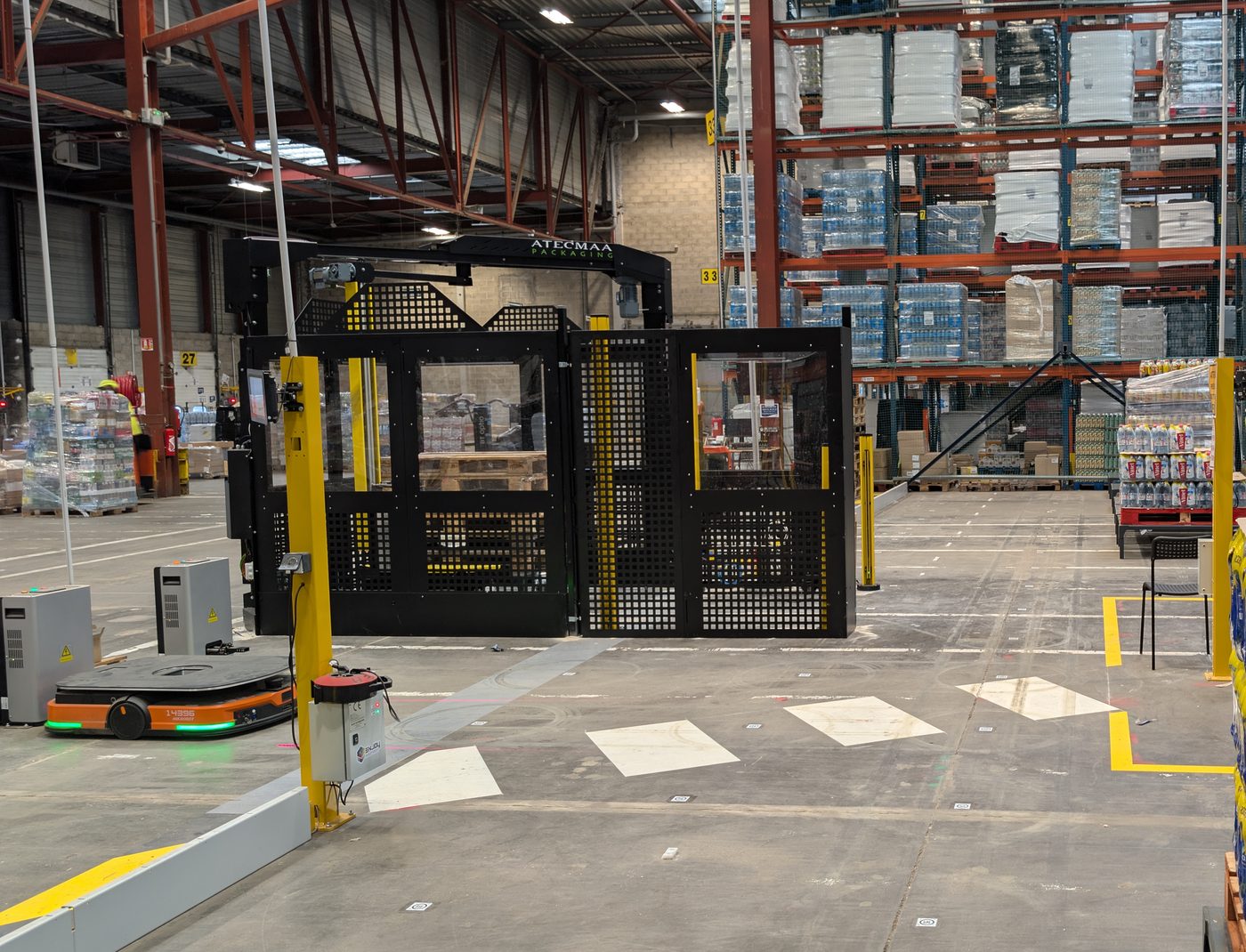 Banderoleuse Atecmaa intégrée à un flux automatisé avec robot mobile