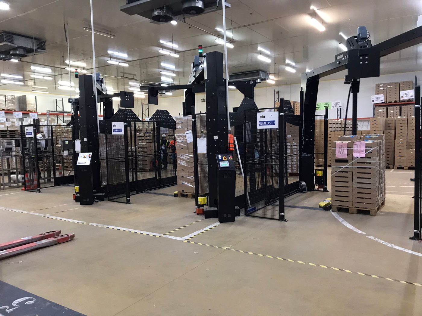 Trois postes de filmage automatisés sur une plateforme logistique